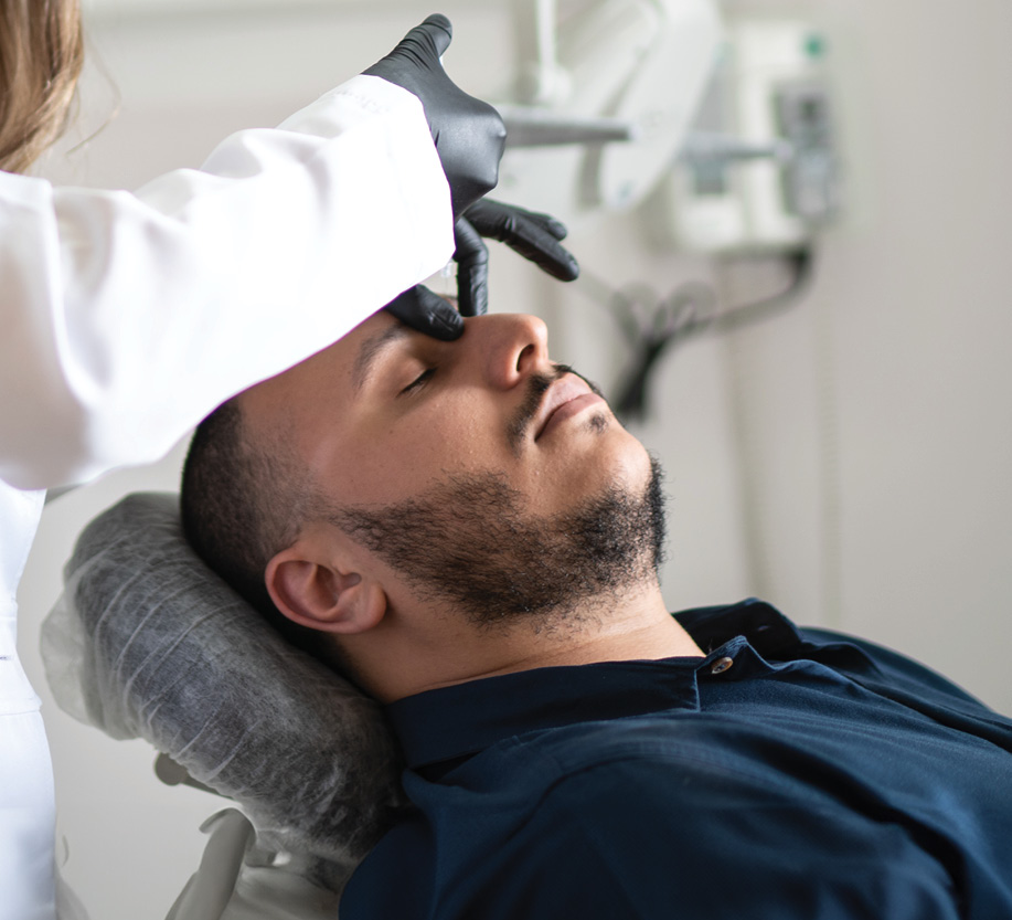 man receiving injections on his nose